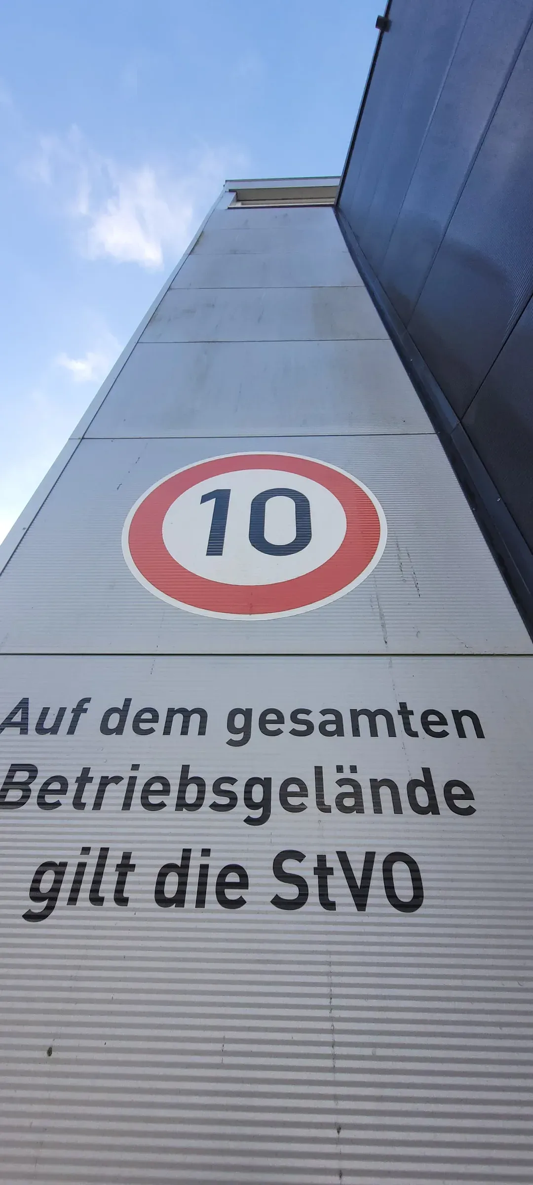 Trapezblechfassade eines Betriebsgebäudes mit grauem Witterungsfilm vor der Fassadenreinigung durch Gebäudedienstleistungen JULE